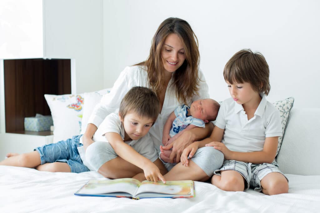 Young,Mother,,Read,A,Book,To,Her,Three,Children,,Boys,